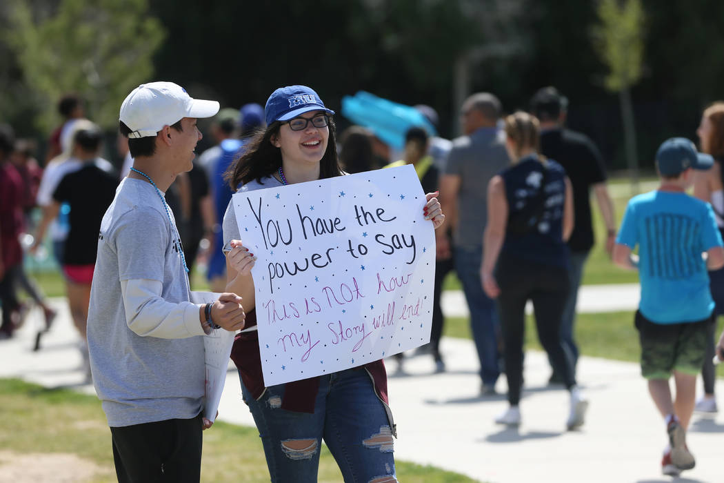 Volunteers Simon Wassmuth, 18, left, and Rachel Constantin, 17, hold up encouragement signs dur ...