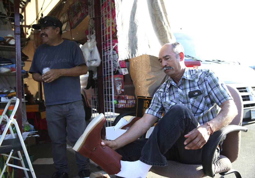 Vendor Javier Rivas, left, helps Pedro Ortega find pair of boots at the Broadacres Marketplace ...