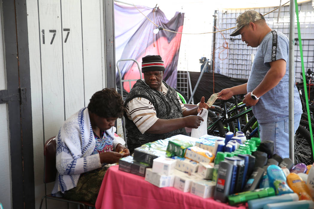 Javier Espino, right, of Las Vegas, buys hygiene products from Wilbert Talice, center, and his ...
