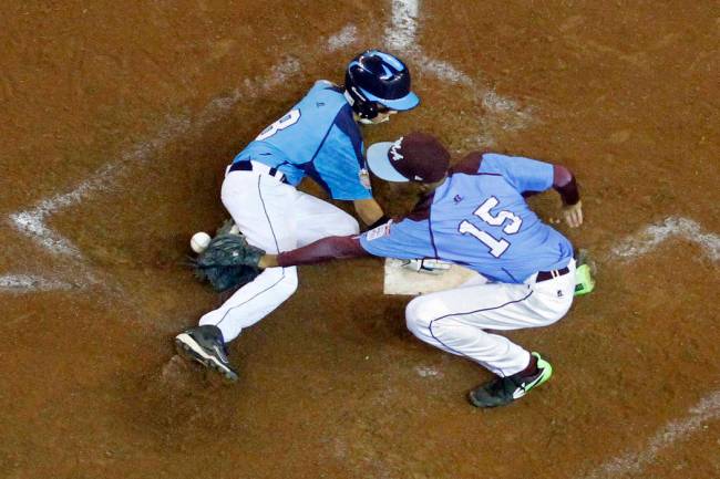 Las Vegas' Dallan Cave (8) scores on a wild pitch by Philadelphia pitcher Kai Cummings (15) in ...