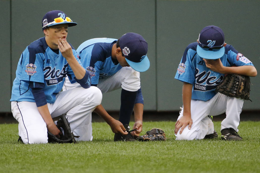 Las Vegas' Dallan Cave, left, Alex Barker, center, and Zach Hare kneel in the outfield during ...