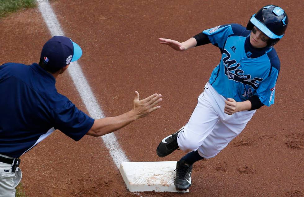 FILE - In this Aug. 17, 2014, file photo, Las Vegas' Brad Stone, right, rounds third to greetin ...