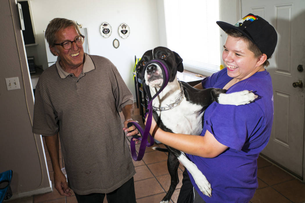 Fifteen-year-old Ryan Lauer, right, holds his dog, Cookie, as his father, Jack Lauer, looks on ...