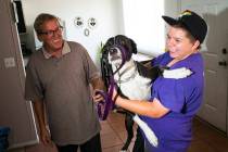 Fifteen-year-old Ryan Lauer, right, holds his dog, Cookie, as his father, Jack Lauer, looks on ...