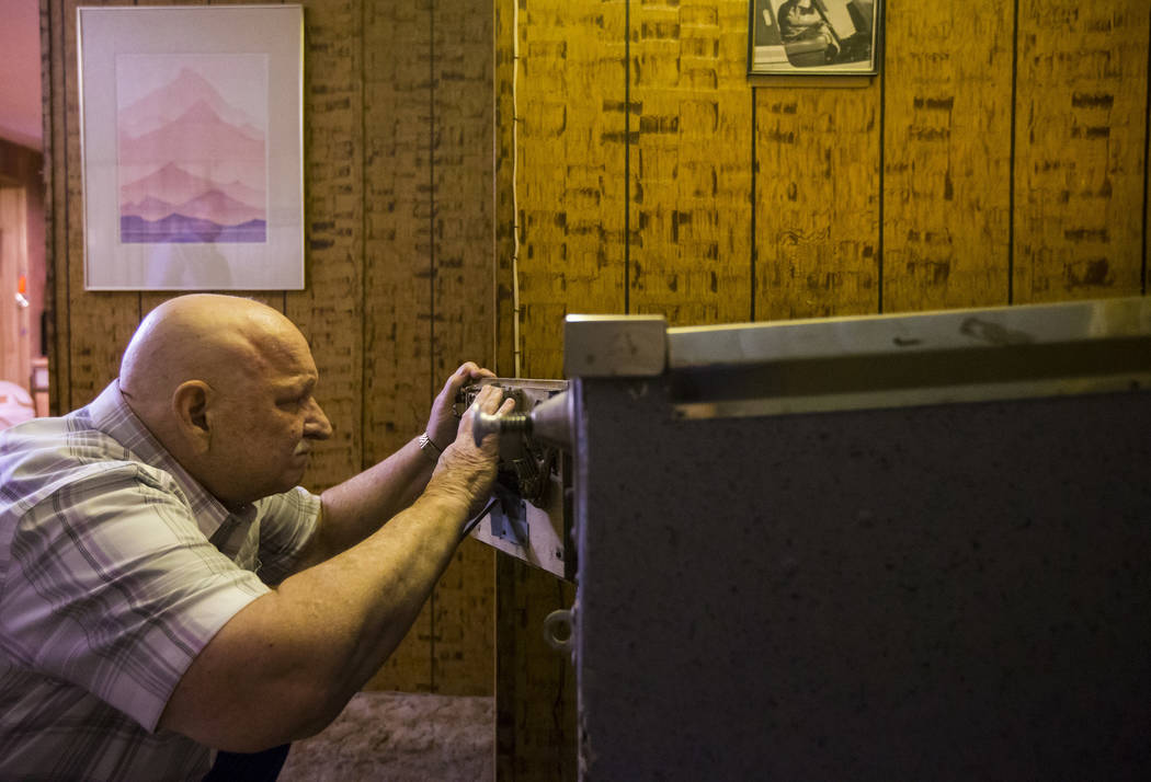 Jerry Kaczmarek works on the "Circus Queen" bingo pinball machine at his home in Bull ...