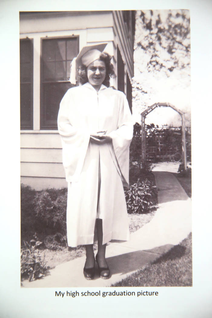 Etta Baykara, 91, shows a picture of herself in her high school graduation gown at her home in ...