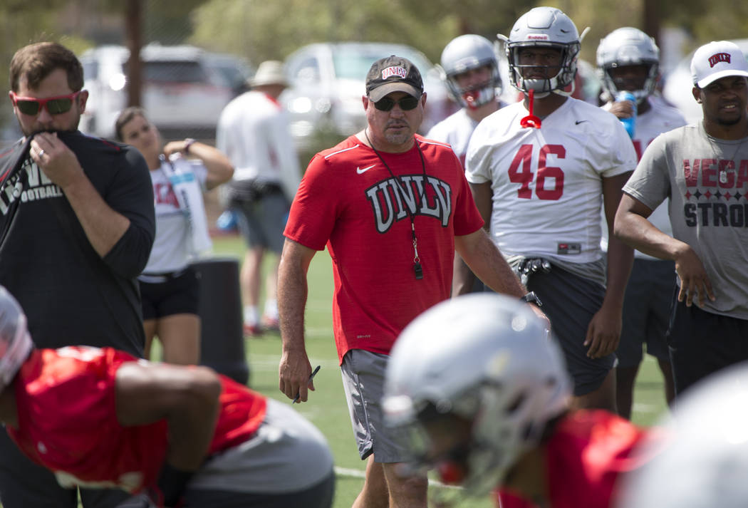 UNLV football coach Tony Sanchez watches over his players as they runs through drills during te ...