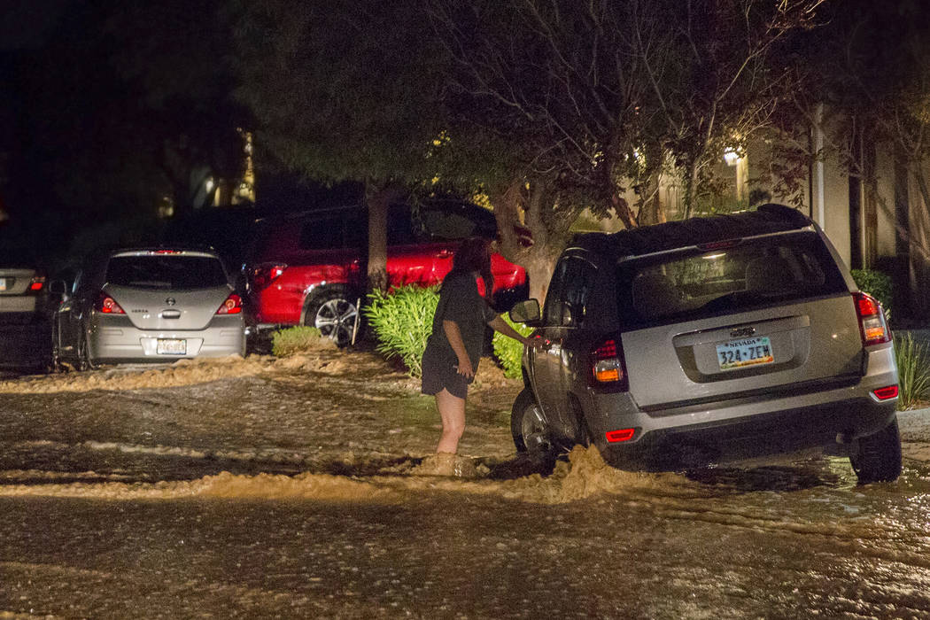 A southwest valley resident, right, tries to move her car out of floodwaters on West Fitzwillia ...