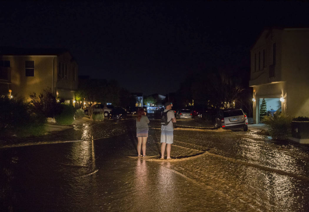 Southwest valley residents watch floodwaters flow past their homes near the intersection of Wes ...