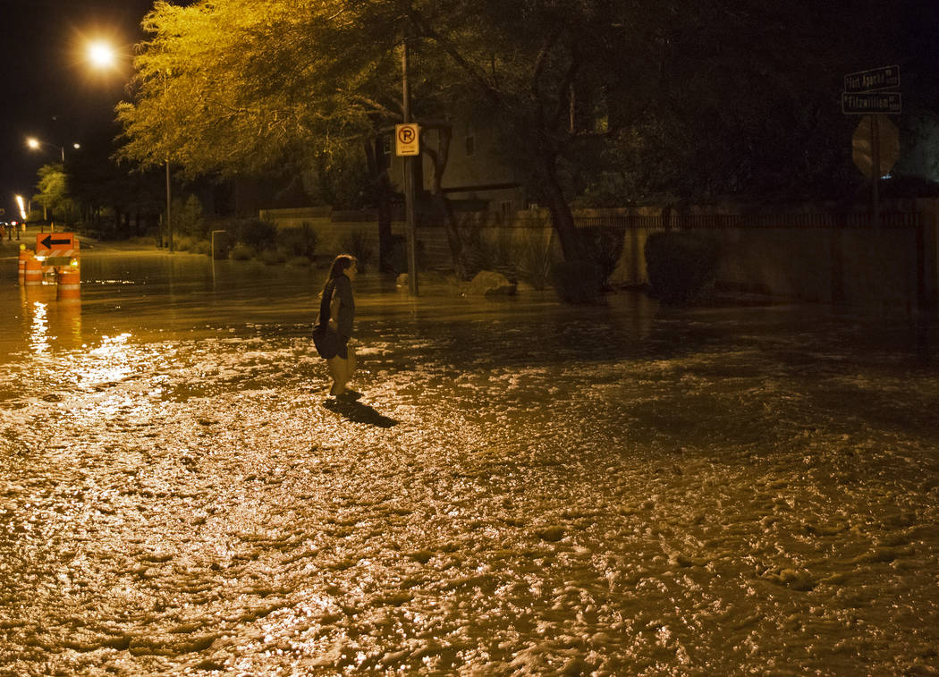 A southwest valley resident tries to cross floodwaters nearing three feet deep at the intersect ...