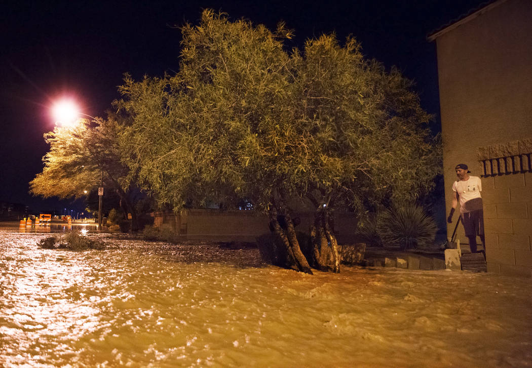 Jonathan Smedley, right, helps his neighbors build a makeshift wall to divert floodwaters from ...