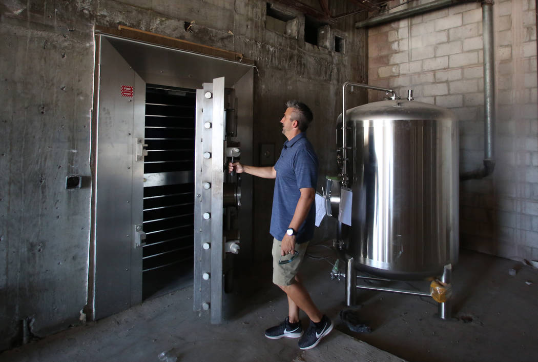 Joe Yakubik, president Assured Development, opens bank volt as he leads a tour of his projects ...