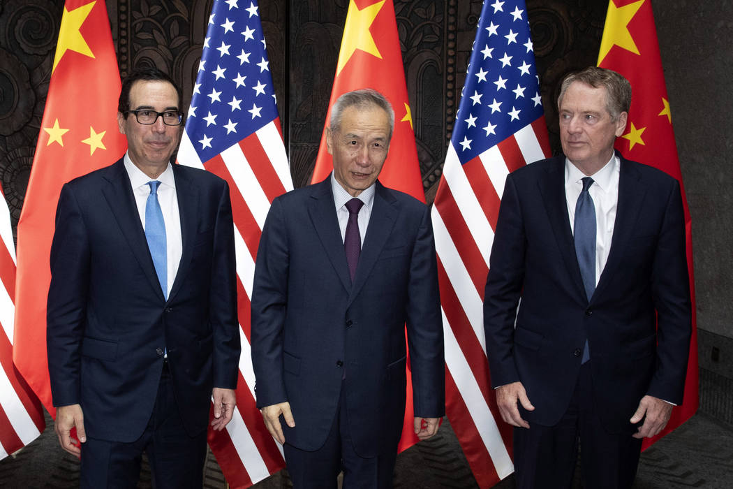 Chinese Vice Premier Liu He, center, poses with U.S. Trade Representative Robert Lighthizer, ri ...