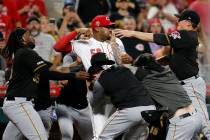 Cincinnati Reds relief pitcher Amir Garrett (50) looks to throw a punch as he is held back by a ...