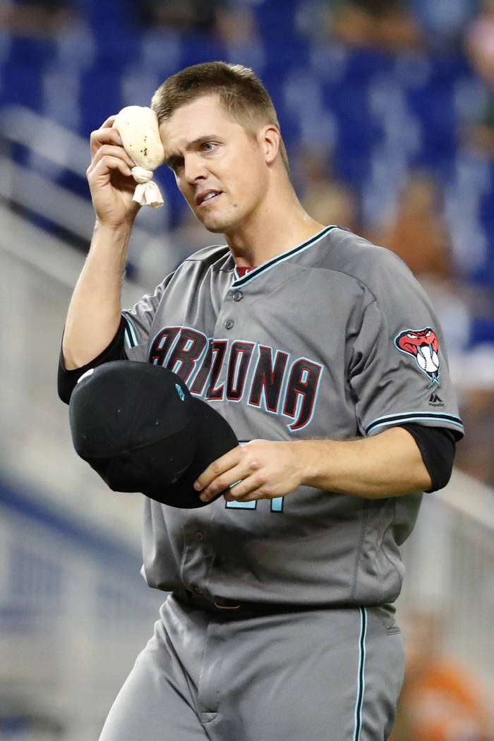 Arizona Diamondbacks starting pitcher Zack Greinke wipes his