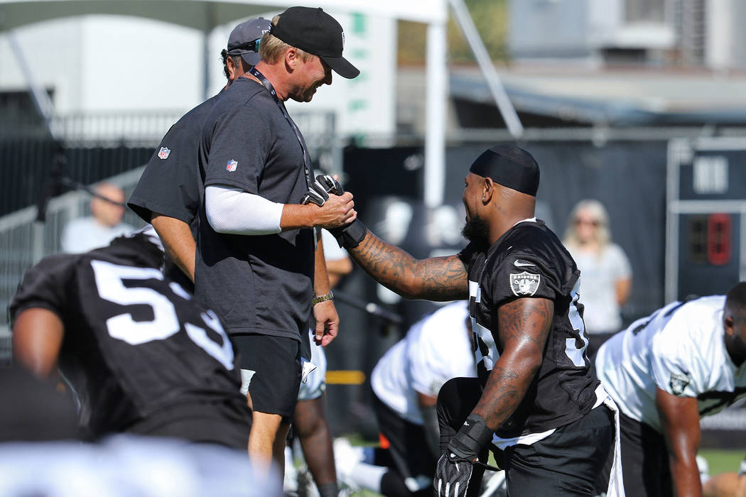Oakland Raiders head coach Jon Gruden, left, shakes hands with linebacker Vontaze Burfict (55) ...