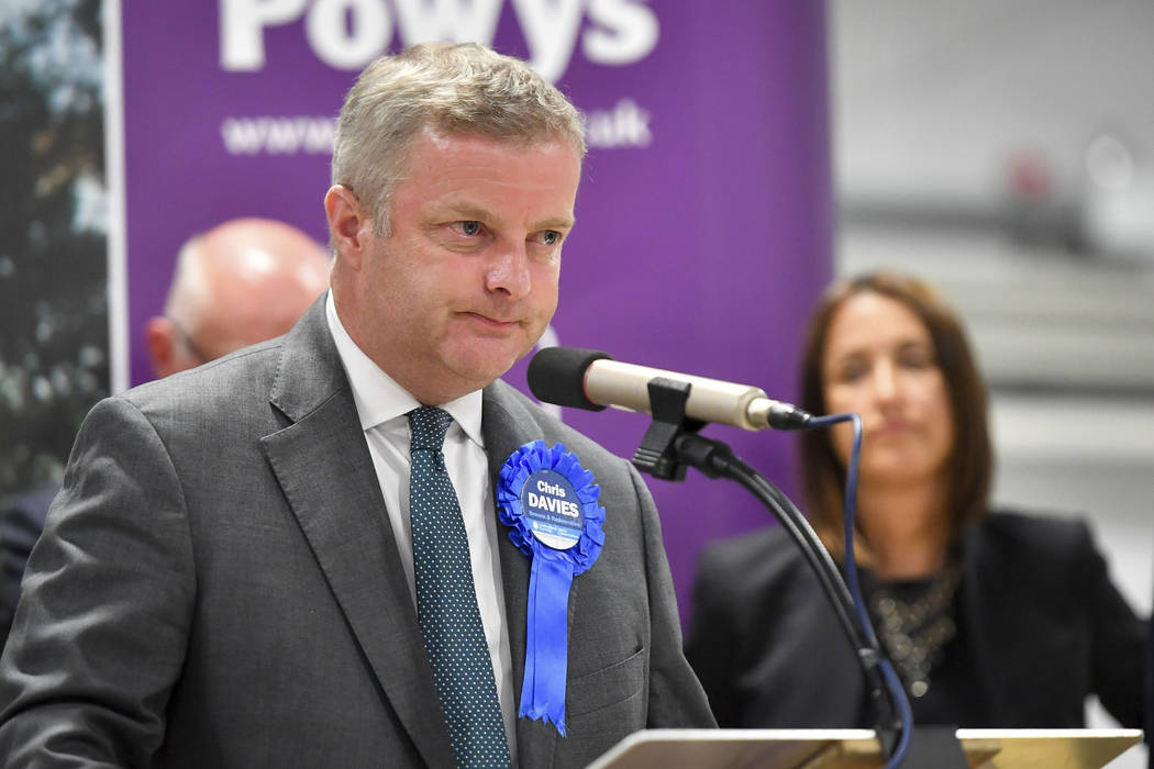 Conservative candidate Chris Davies speaks on stage as Liberal Democrats' Jane Dodds, rear righ ...