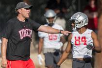 UNLV offensive coordinator Garin Justice, left, talks with wide receiver Steve Jenkins during t ...