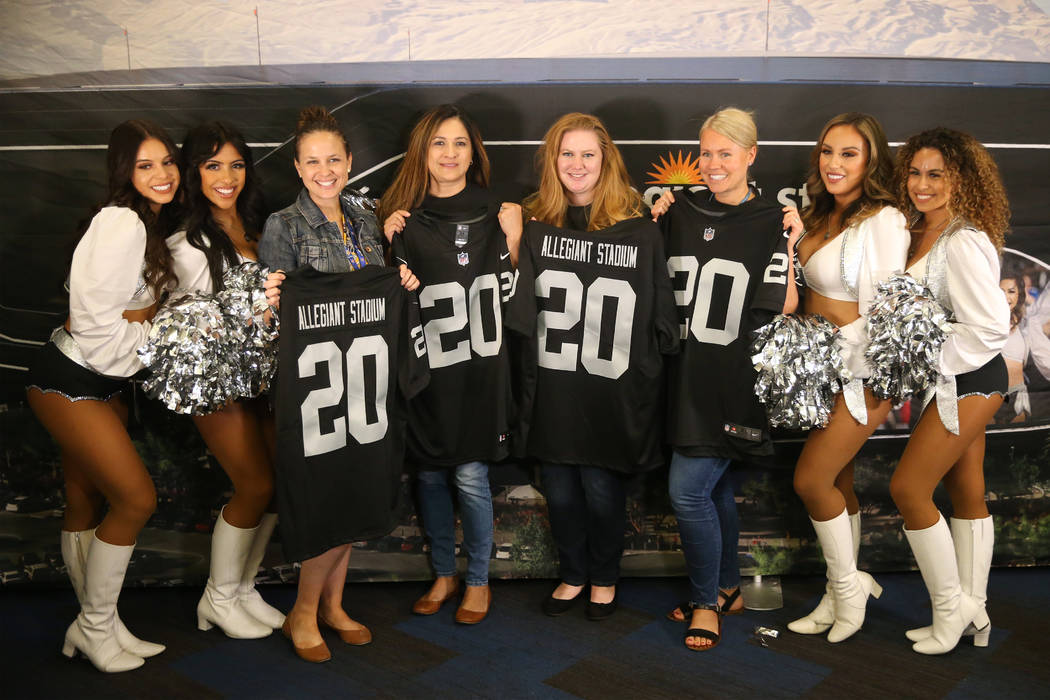 Allegiant employees pose with the Oakland Raiderettes during a celebration at the Allegiant hea ...