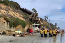 Lifeguards and search and rescue personnel work at the site of a cliff collapse at a popular be ...