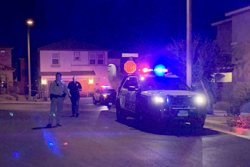 Police officers investigate after two people were found dead at a home in the 7800 block of Air ...