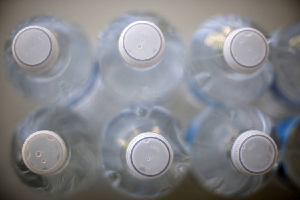 Drinking water in plastic bottles is seen on a cafeteria table in Los Angeles on Friday, Aug. 2 ...