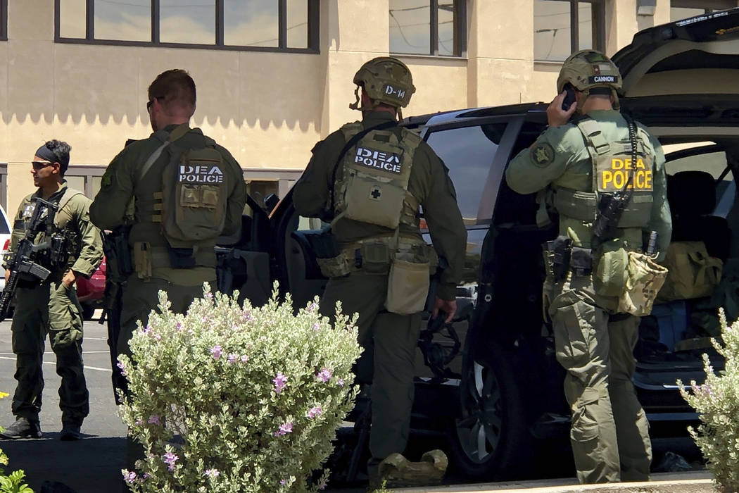 Law enforcement from different agencies work the scene of a fatal shooting at a shopping mall ...