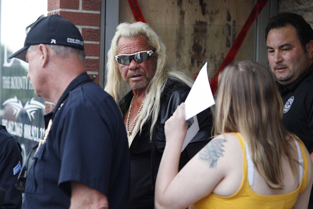 Duane "Dog the Bounty Hunter" Chapman, back, charts with his daughter, Bonnie Jo, outside his s ...