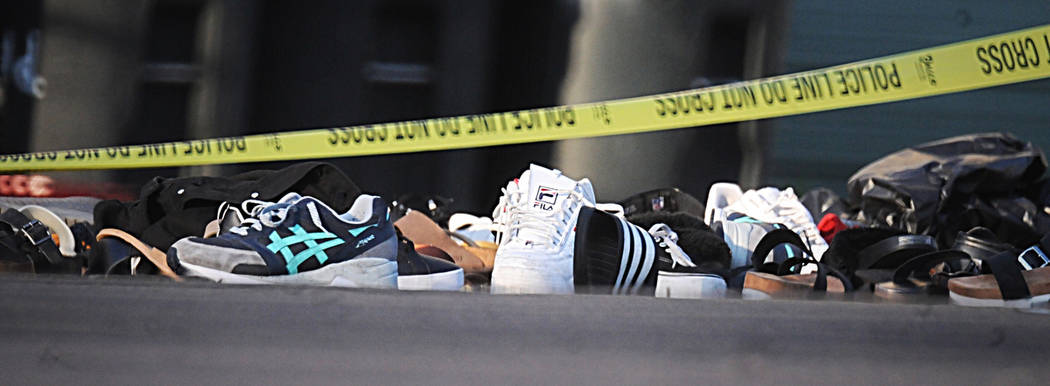 Police tape drapes over a pile of shoes after a mass shooting in Dayton, Ohio on Sunday, Aug, 4 ...