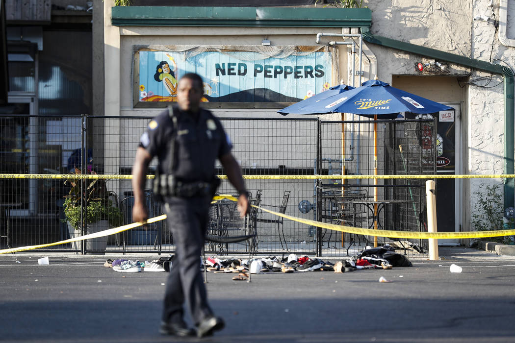 Shoes are piled outside the scene of a mass shooting including Ned Peppers bar, Sunday, Aug. 4, ...