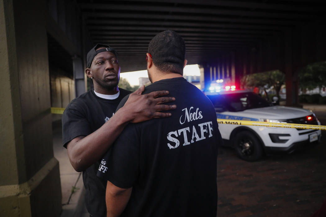 Witnesses comfort one another at the scene of a mass shooting, Sunday, Aug. 4, 2019, in Dayton, ...