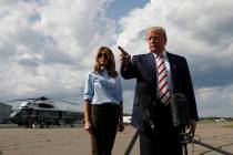 President Donald Trump, with first lady Melania Trump, speaks to the media before boarding Air ...