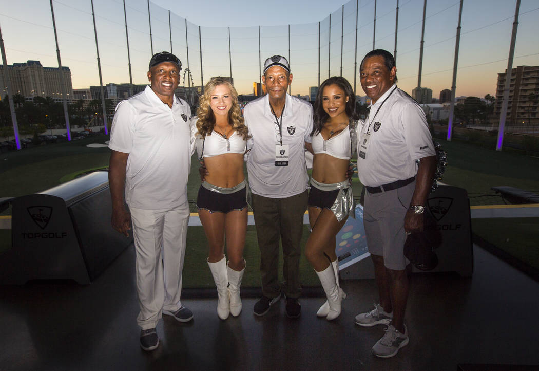 The Oakland Raiderettes pose with former players Tim Brown, Willie Brown and Cliff Branch durin ...