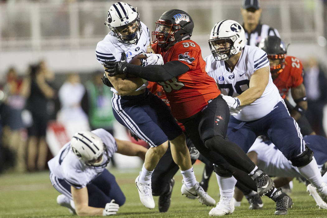 UNLV Rebels defensive lineman Nick Dehdashtian (98) tackles Brigham Young Cougars running back ...