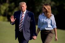 President Donald Trump waves to members of the media as he and first lady Melania Trump walk ac ...
