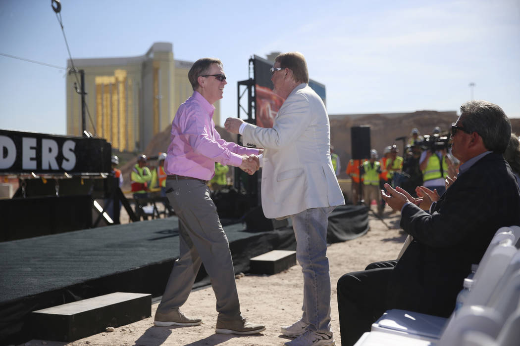 Allegiant Chairman and CEO Maury Gallagher, left, shakes hands with Raiders Owner Mark Davis du ...