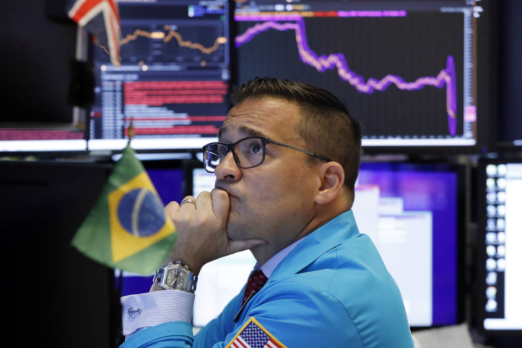 Specialist Paul Cosentino works on the floor of the New York Stock Exchange, Monday, Aug. 5, 20 ...