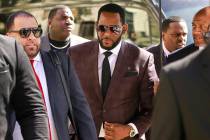 R&B singer R. Kelly, center, arrives at the Leighton Criminal Court building for an arraignment ...