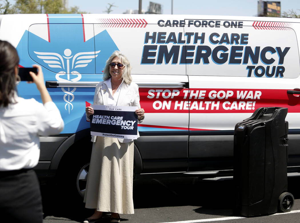 U.S. Rep. Dina Titus, D-Nev., takes a photo in front of the Protect Our Care's nationwide bus ...