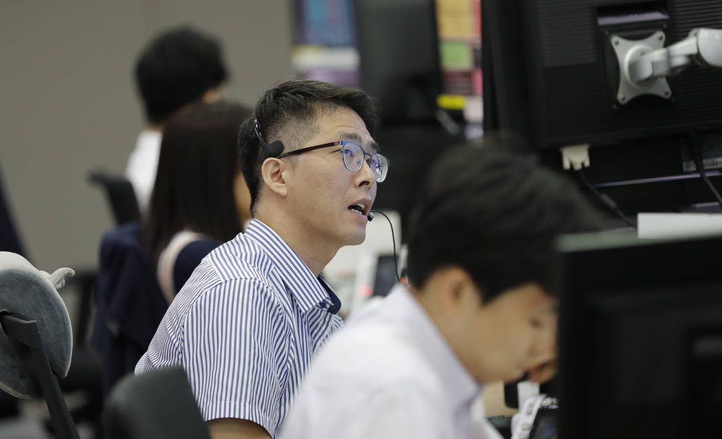 A currency trader talks on the phone at the foreign exchange dealing room in Seoul, South Korea ...