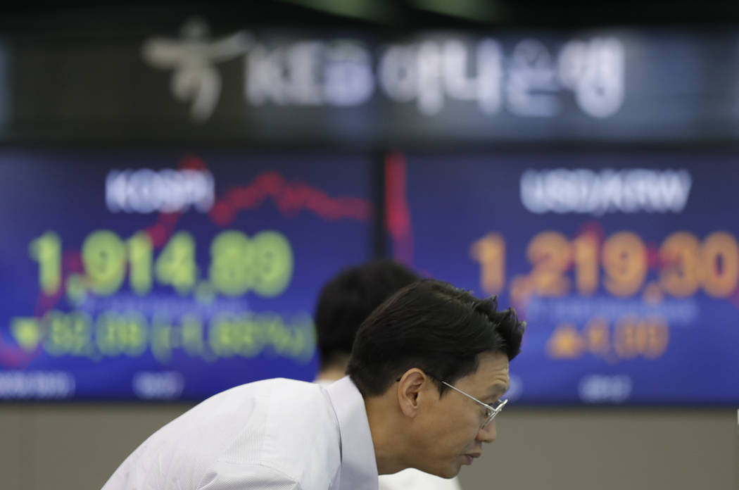 A currency trader watches the computer monitors near the screens showing the Korea Composite St ...