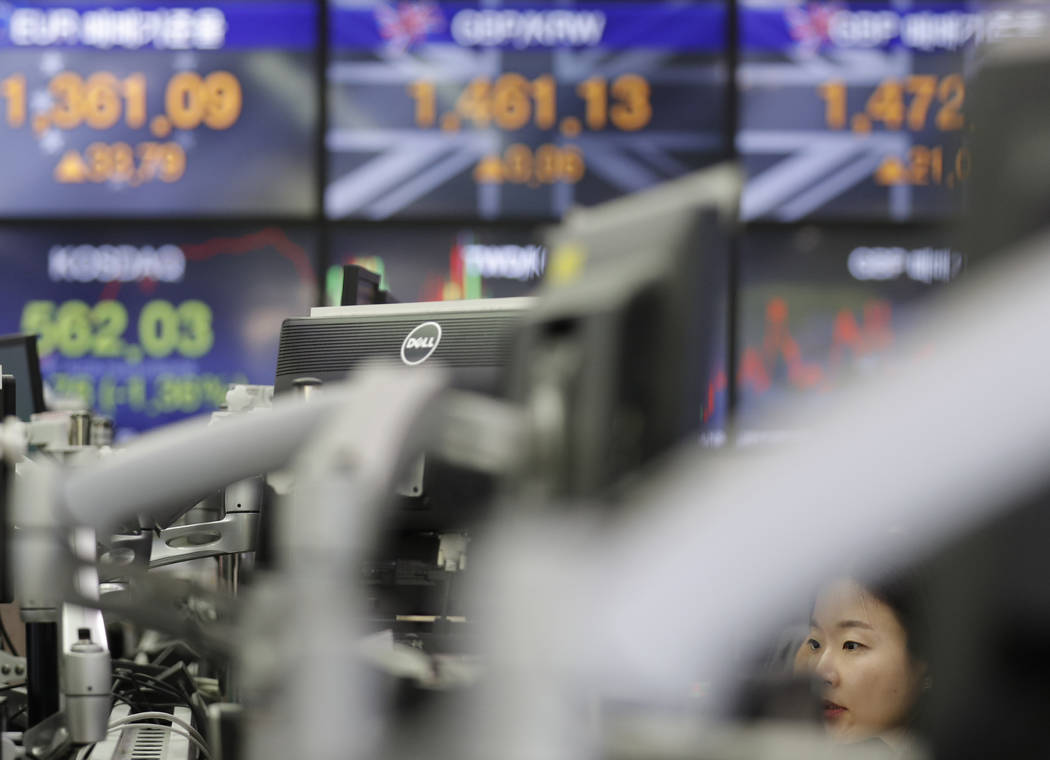 A currency trader watches the computer monitors at the foreign exchange dealing room in Seoul, ...