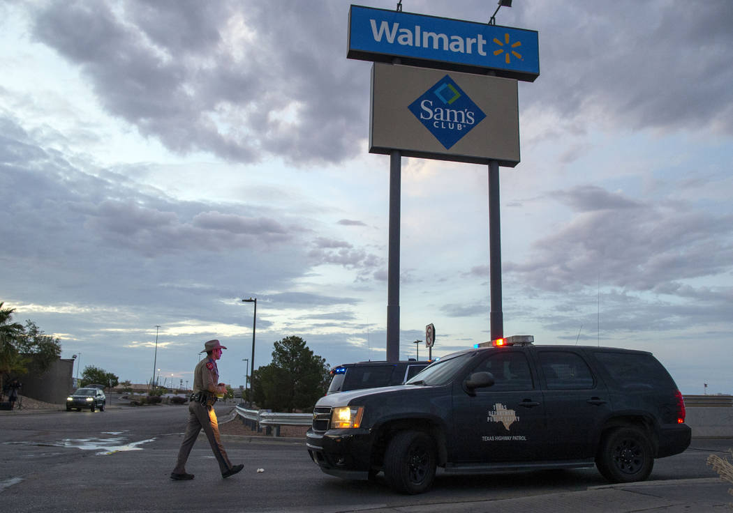 FILE - In this Aug. 4, 2019, file photo a Texas State Trooper walks back to his car while provi ...