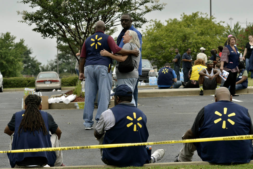 In a July 30, 2019, file photo Walmart employees gather in a nearby parking lot after a shootin ...