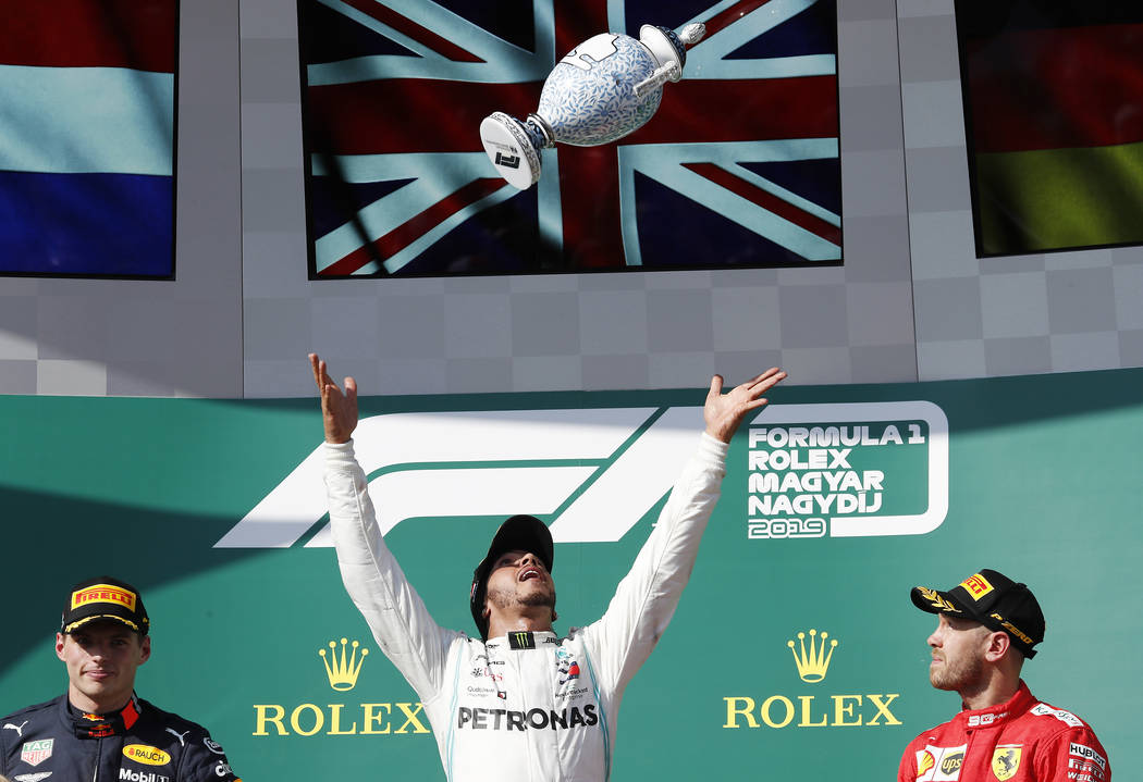 Mercedes driver Lewis Hamilton, center, of Britain, celebrates on the podium with second placed ...