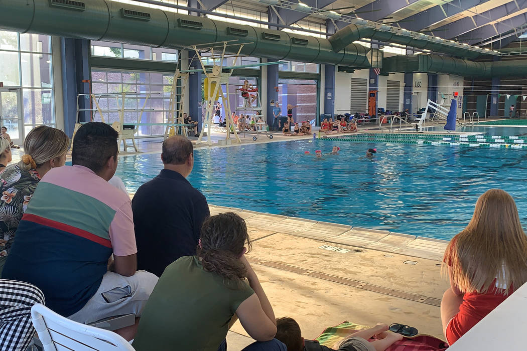 The crowd watched as a team of swimmers performed a routine at the “Through the Decades” a ...