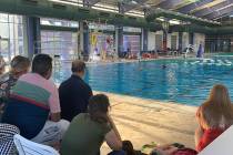 The crowd watched as a team of swimmers performed a routine at the “Through the Decades” a ...