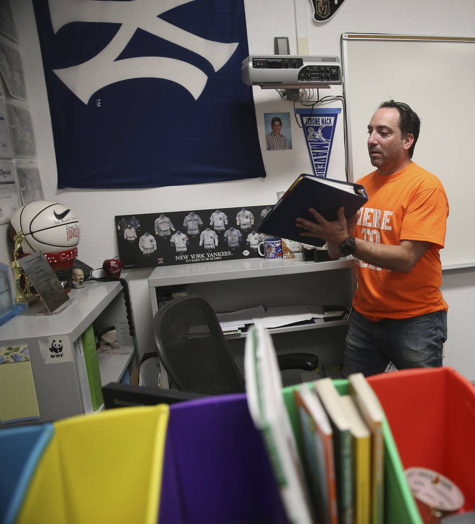 English teacher Lloyd Goldberg pulls out a binder filled with school material applications for ...