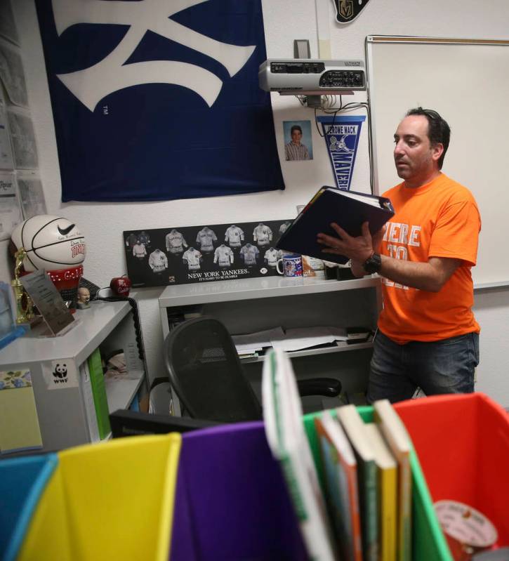 English teacher Lloyd Goldberg pulls out a binder filled with school material applications for ...