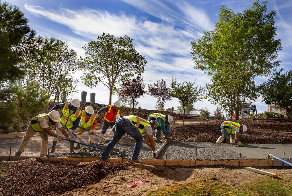 Construction crew lay a concrete path at Wynn Golf Club on Tuesday, July 30, 2019, in Las Vegas ...